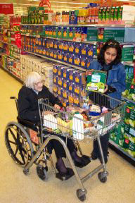 Wheelchair user being helped with shopping