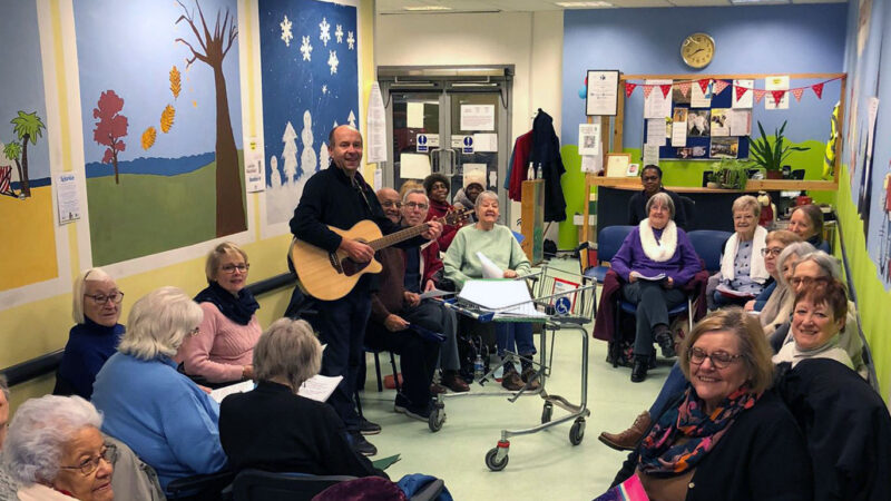 Choir Rehearsal at Shopmobility, led by Manuel on guitar