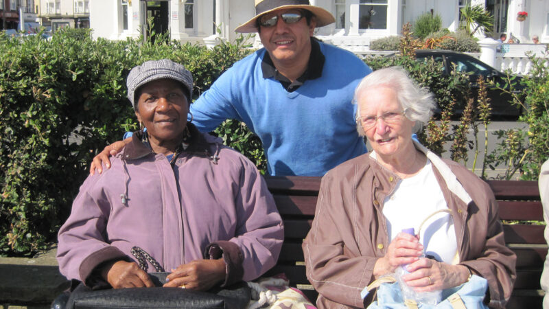 Day trip to the Coast - three people on a bench by seaside