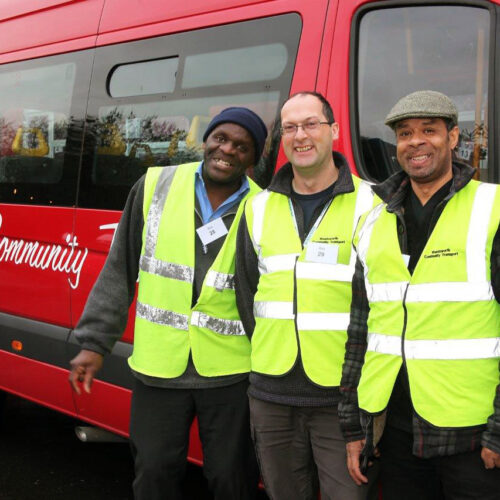 Three drivers by a bus